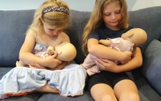 Girls breastfeeding their dolls