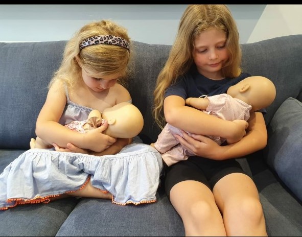 Girls breastfeeding their dolls