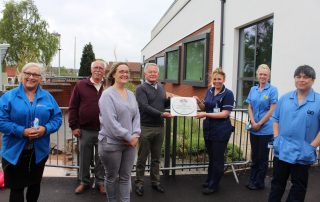 Volunteers hand over the special plaque to critical care staff