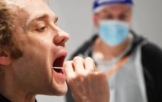 Man taking a swab for a lateral flow Covid-19 test