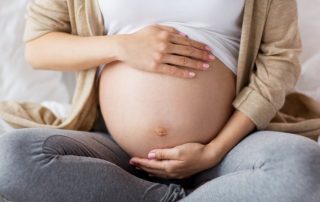 Pregnant woman cradling her stomach