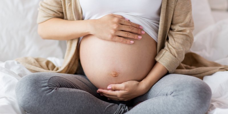 Pregnant woman cradling her stomach