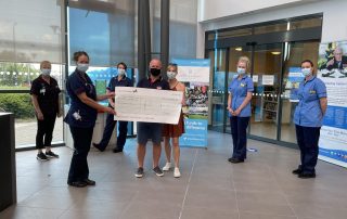 Ian and family hand over a cheque