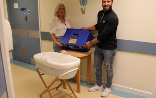 Laura and Dan with the cuddle cot they raised money for