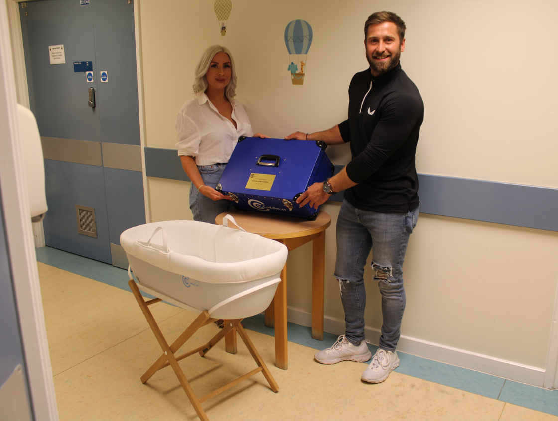 Laura and Dan with the cuddle cot they raised money for