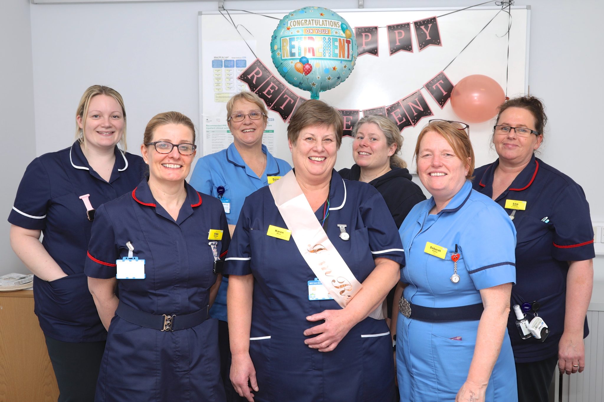 Karen is pictured in the middle of her colleagues on her last day