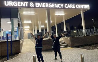 Happy project team leads outside the new entrance