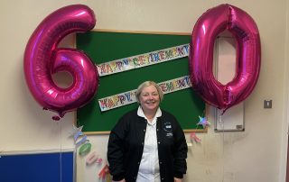 Liz with her 60 birthday balloons and retirement bunting