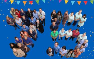 Staff form the number 75 to mark the NHS birthday