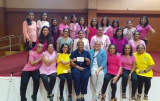 The ladies' group hands over a cheque.