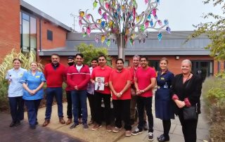 Mr Bains' friends hand over the cheque at Goscote Hospice