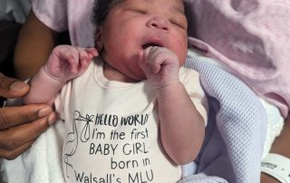 Baby Zadia in her special babygro for being the first baby girl to arrive in the relocated Midwifery-Led Unit