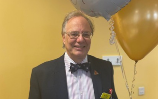 Dr Chris Newson, Consultant Anaesthetist, holds balloon at retirement party.