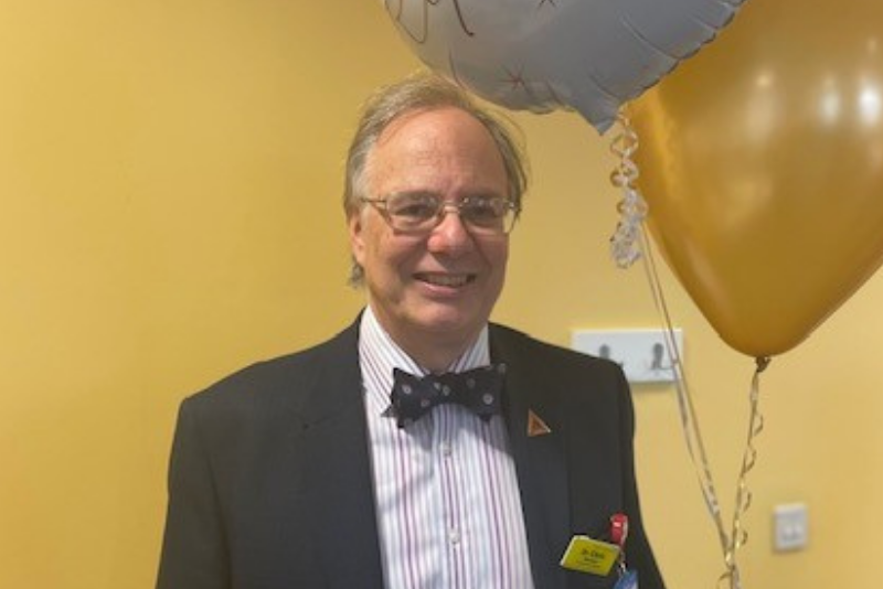 Dr Chris Newson, Consultant Anaesthetist, holds balloon at retirement party.