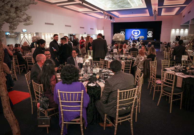 Staff gathered at the 2026 Caring for All Awards - some seated, some socialising as the event is about to begin.