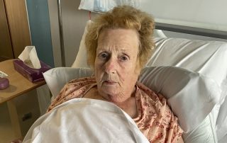 Patient Kathleen Sargent lies in hospital bed having had flu.