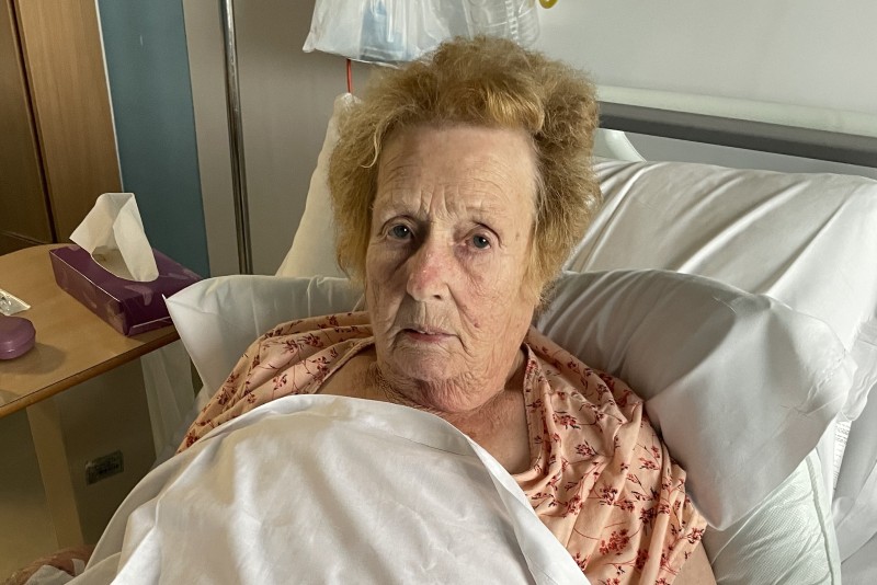 Patient Kathleen Sargent lies in hospital bed having had flu.
